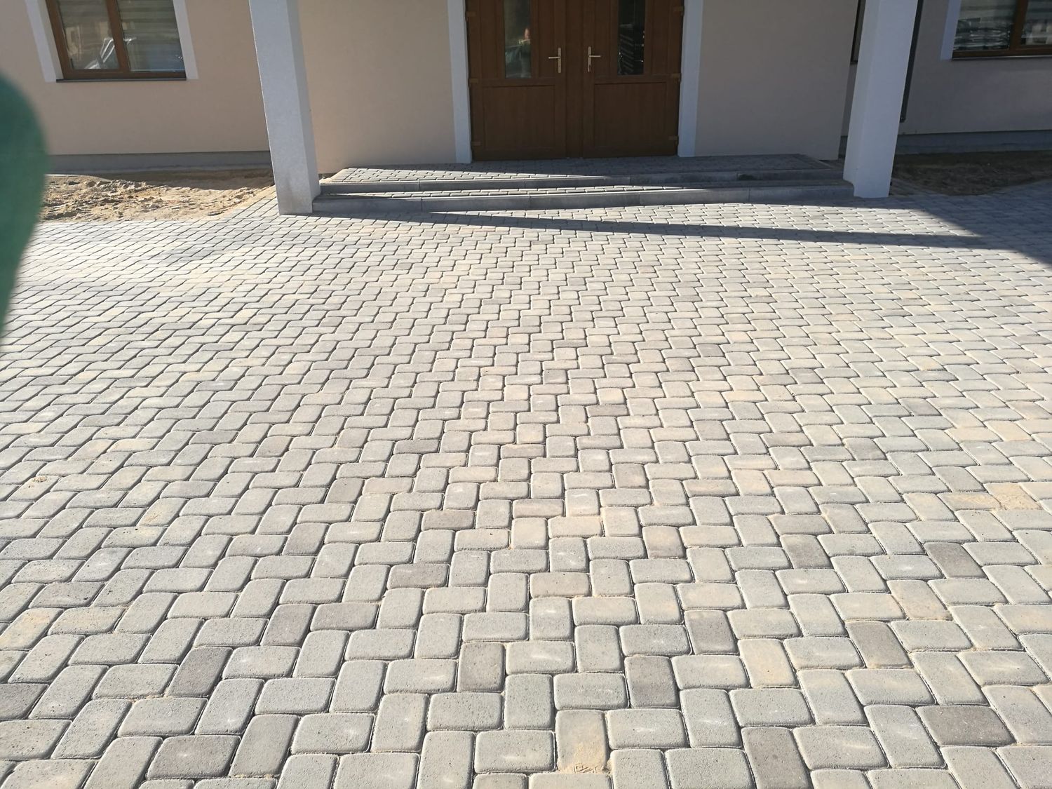 Piebraucamā ceļa bruģēšana skujiņas rakstā pie ieejas